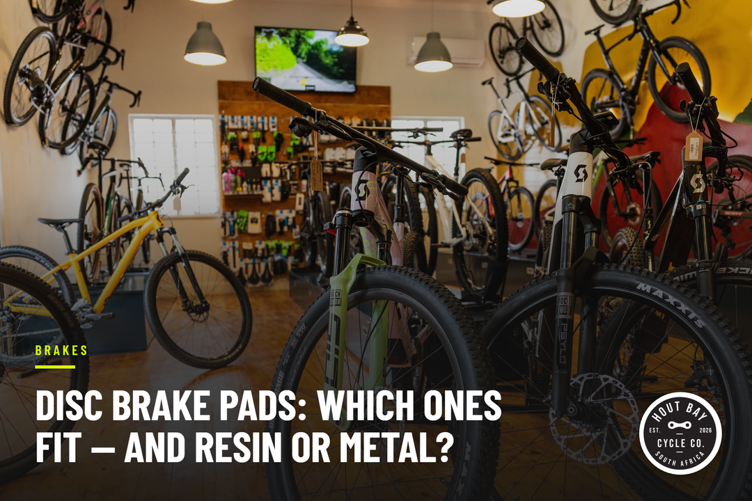 Mountain bikes at floor level in the Hout Bay Cycle Co showroom, forks and disc rotors in view, with the headline Disc brake pads: which ones fit — and resin or metal?