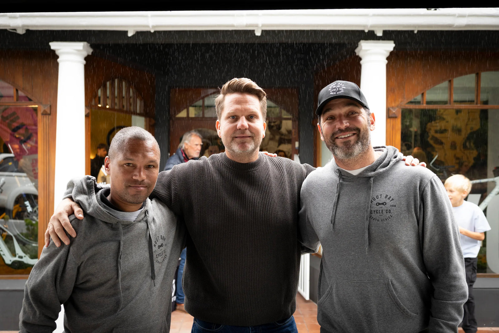 John Van Wyk and Bryan Nicholson of Hout Bay Cycle Co outside the shop on Main Road in the rain